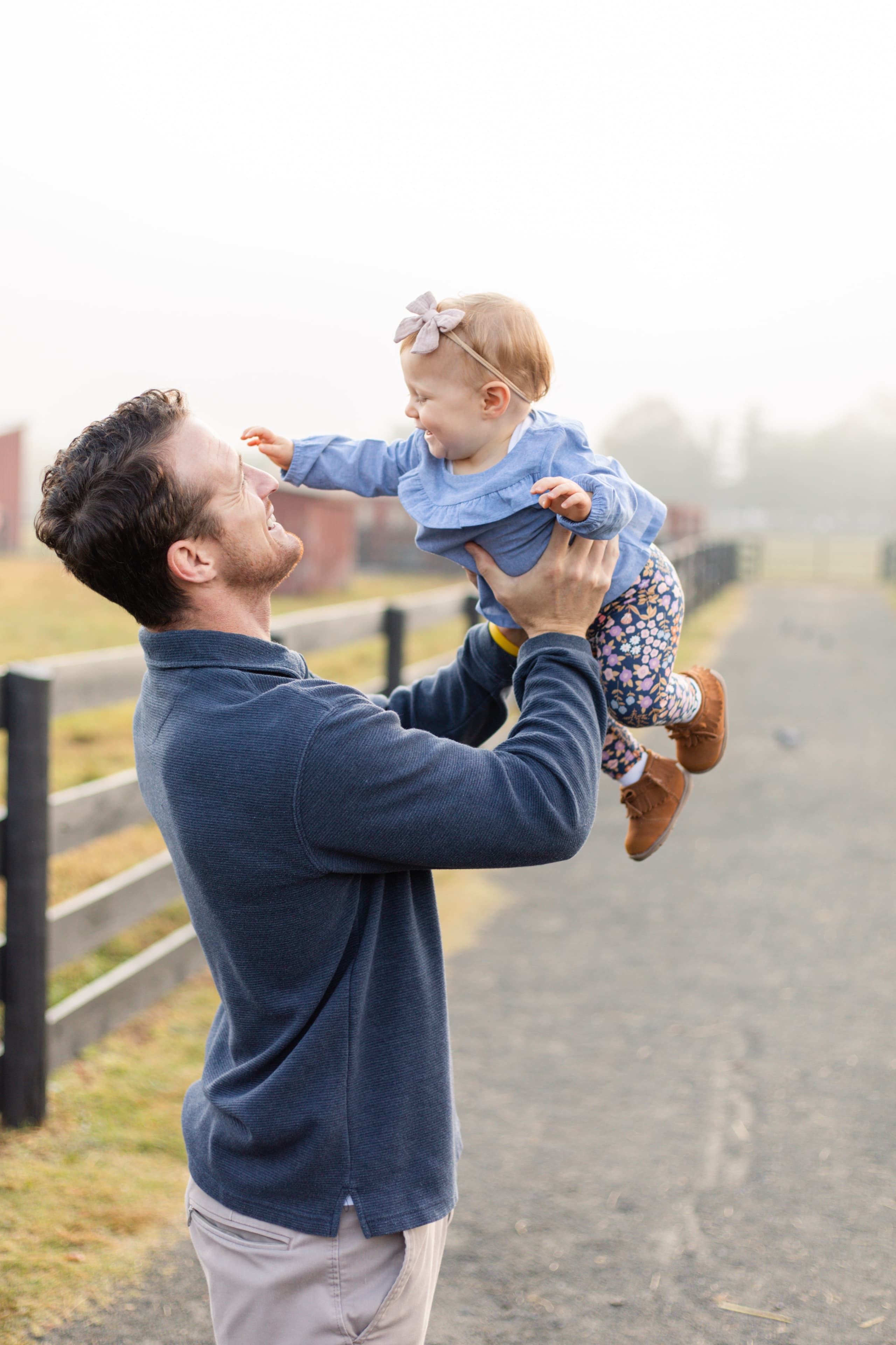 Father lifting his laughing baby girl into the air