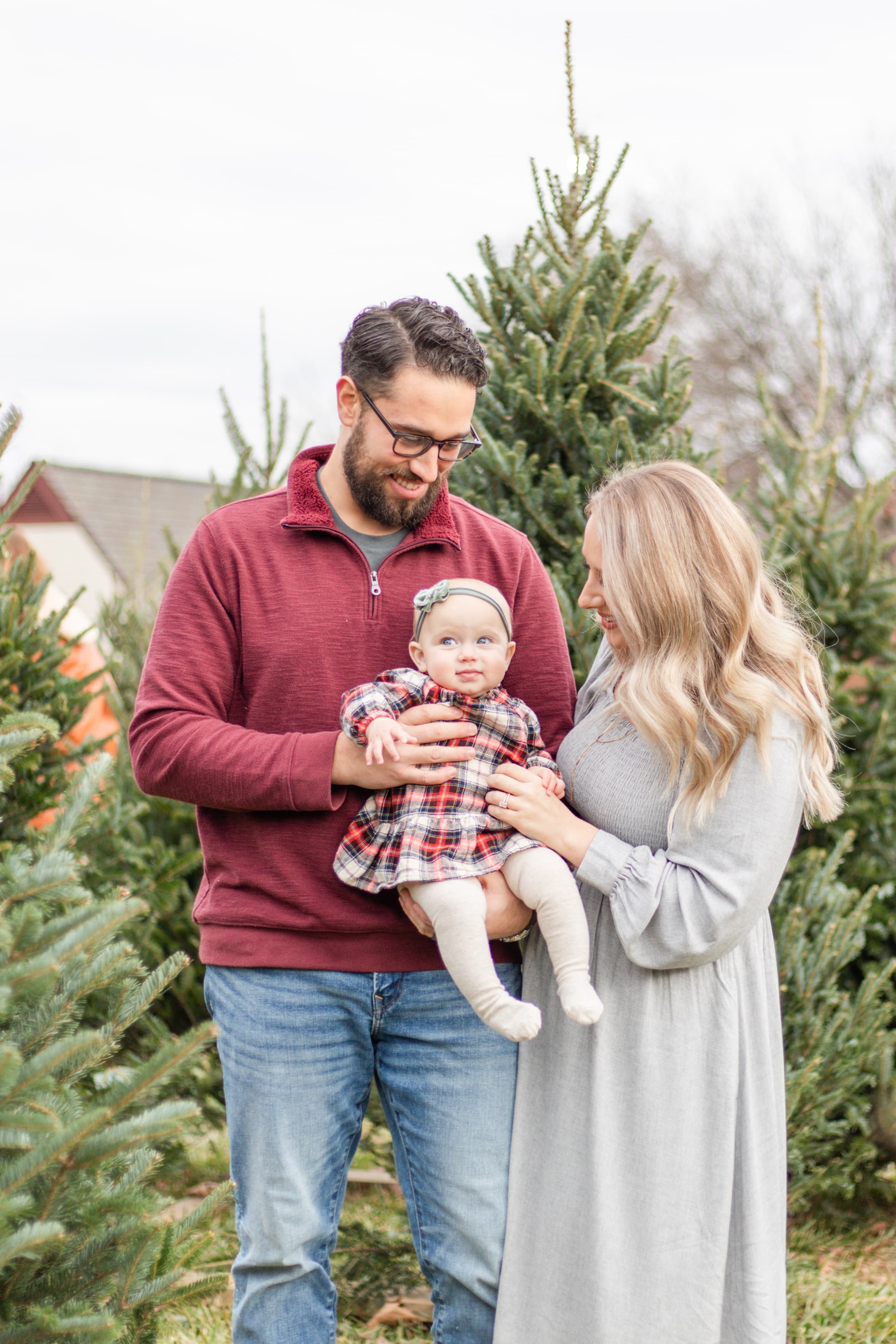 Family with their baby at a Christmas tree farm