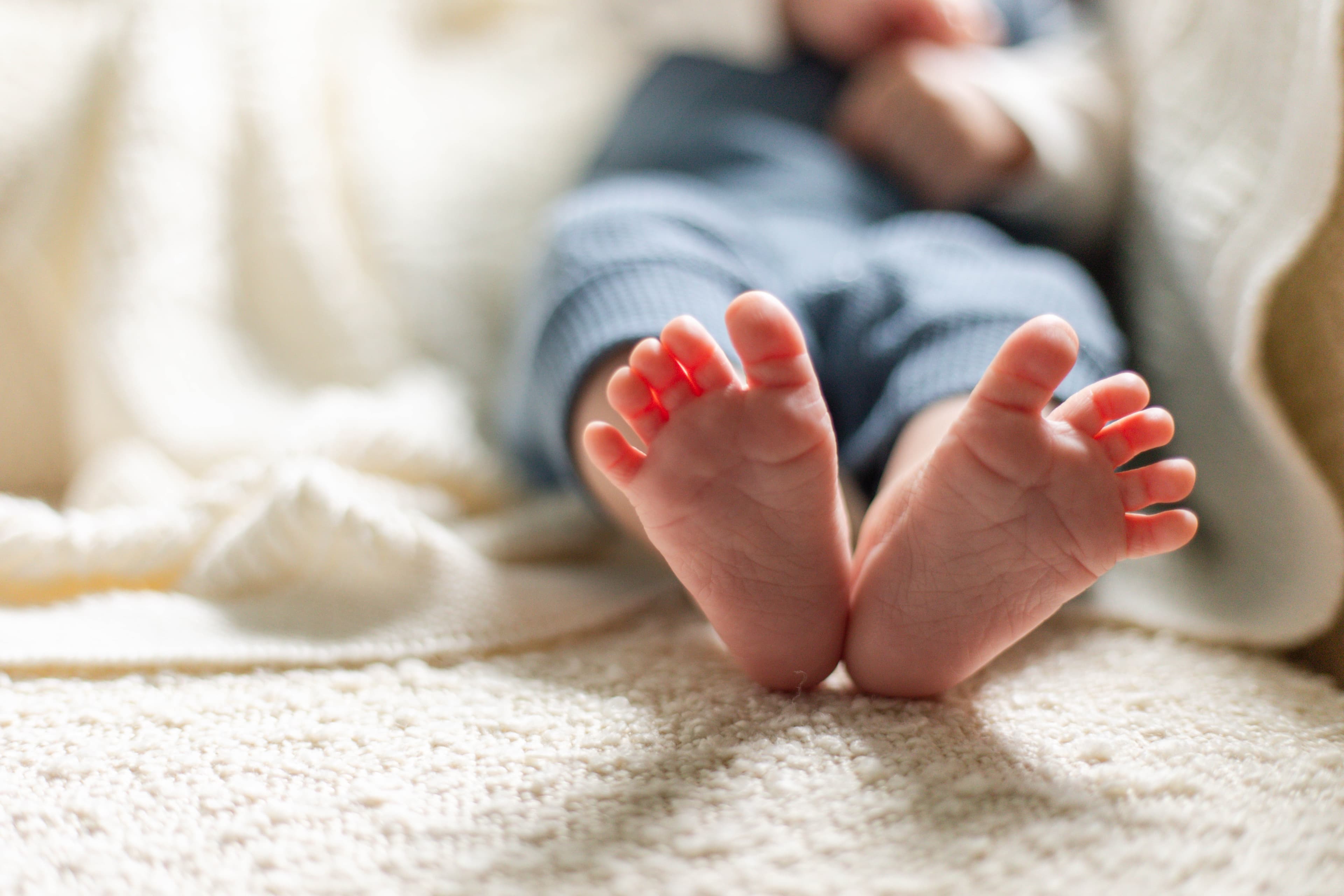 Newborn feet cradled in warm light